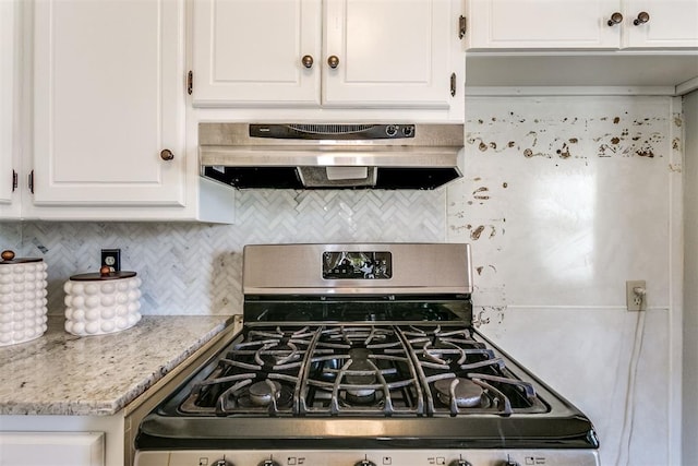 kitchen with backsplash, light stone counters, stainless steel range, extractor fan, and white cabinetry