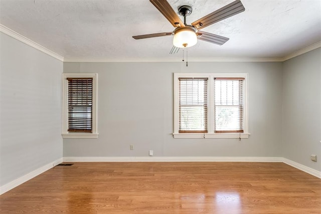 spare room with ceiling fan, ornamental molding, and light wood-type flooring