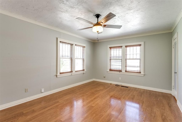 unfurnished room with hardwood / wood-style floors, a healthy amount of sunlight, and crown molding