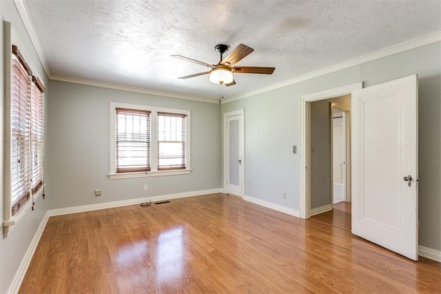 empty room featuring a textured ceiling, light wood-type flooring, ceiling fan, and crown molding