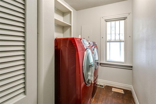 washroom with dark hardwood / wood-style flooring, washing machine and dryer, and a textured ceiling