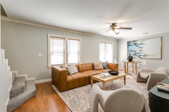 living room featuring ceiling fan, wood-type flooring, and ornamental molding