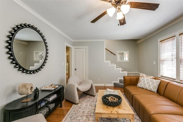 living room featuring a textured ceiling, ceiling fan, wood-type flooring, and ornamental molding