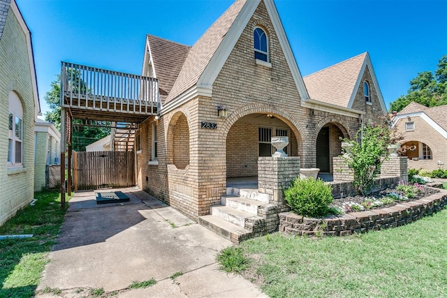 tudor-style house with a front lawn and a porch