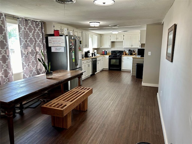 kitchen featuring white cabinets, a textured ceiling, stainless steel appliances, and dark hardwood / wood-style floors