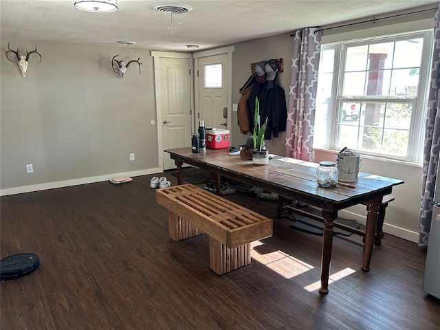 dining room with plenty of natural light and dark hardwood / wood-style flooring