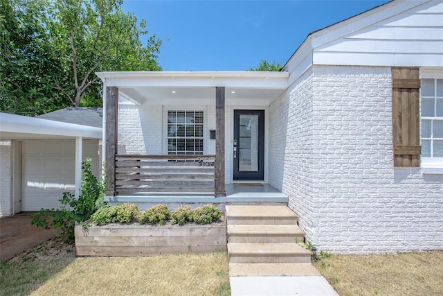 entrance to property featuring a porch and a garage