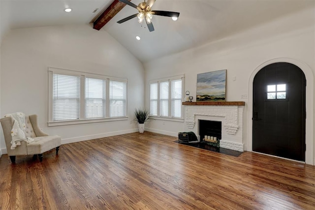 unfurnished living room with hardwood / wood-style floors, high vaulted ceiling, a brick fireplace, ceiling fan, and beamed ceiling