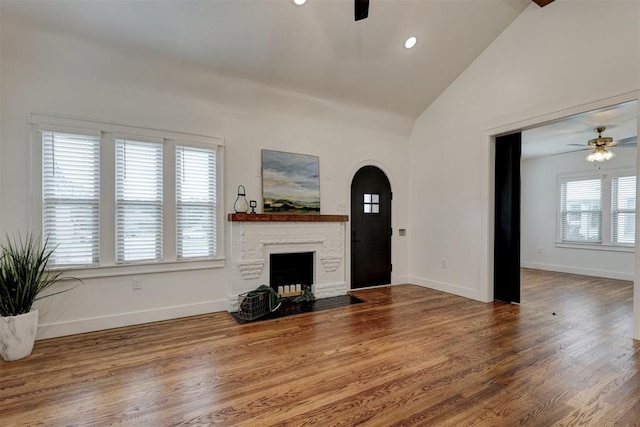 unfurnished living room featuring hardwood / wood-style floors, vaulted ceiling, and ceiling fan