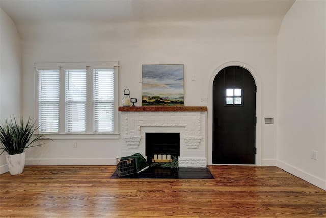 living room with a wealth of natural light, lofted ceiling, and hardwood / wood-style flooring