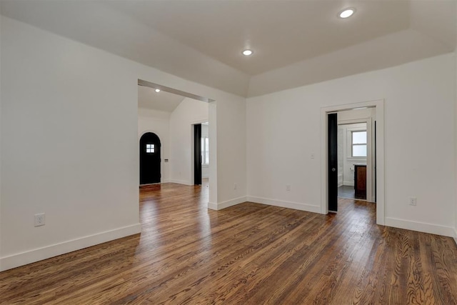 spare room with dark hardwood / wood-style flooring and lofted ceiling