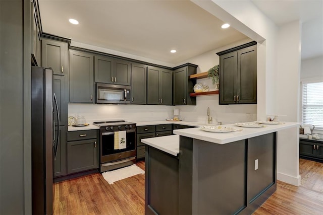 kitchen featuring sink, stainless steel appliances, a breakfast bar area, and light hardwood / wood-style flooring