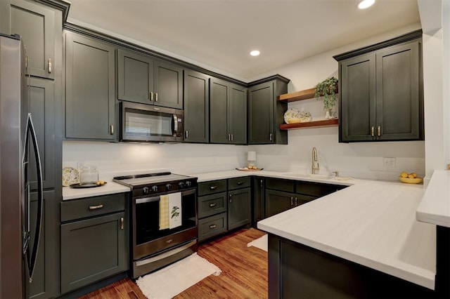 kitchen with sink, light wood-type flooring, and appliances with stainless steel finishes