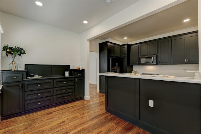 kitchen with black fridge and light hardwood / wood-style flooring