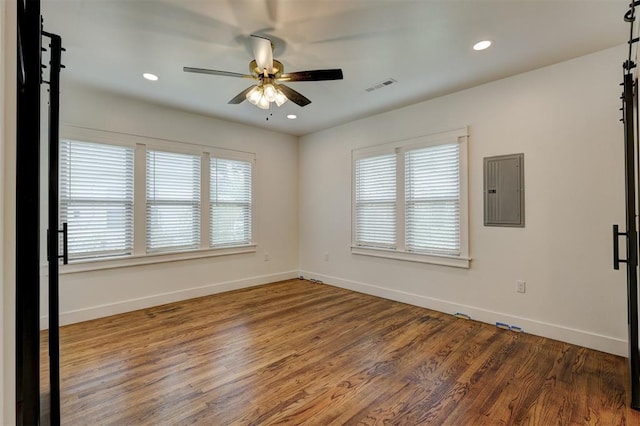 spare room featuring electric panel, ceiling fan, and dark hardwood / wood-style floors