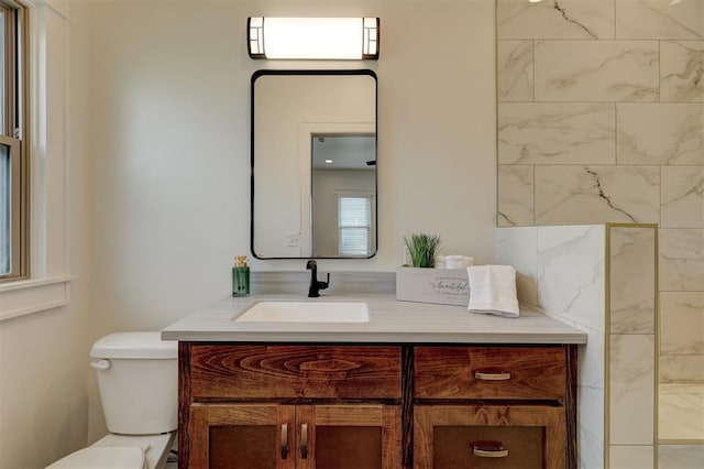 bathroom featuring a shower, vanity, and toilet