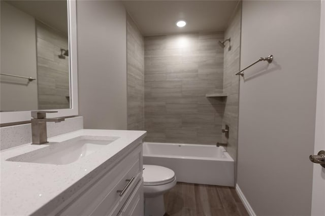 full bathroom with vanity, toilet, wood-type flooring, and tiled shower / bath