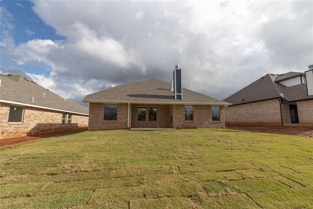 rear view of property with a lawn