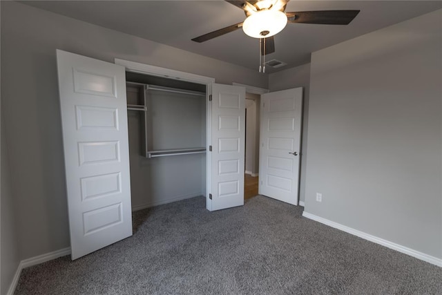 unfurnished bedroom featuring ceiling fan, dark carpet, and a closet