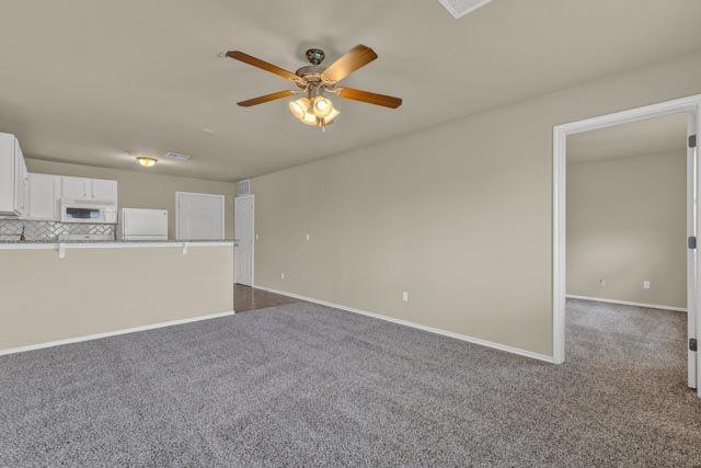 unfurnished living room with carpet flooring and ceiling fan