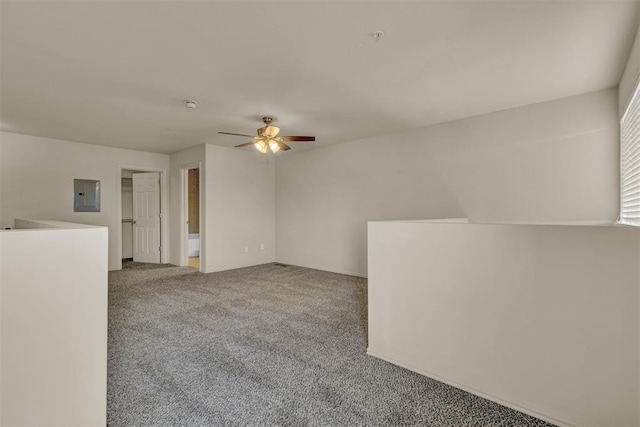 empty room with electric panel, ceiling fan, and carpet floors