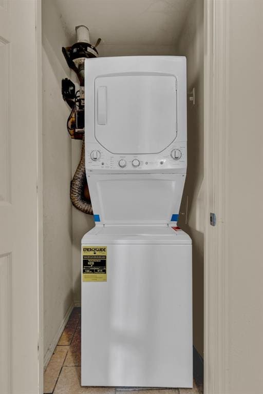 washroom featuring light tile patterned flooring and stacked washer / dryer