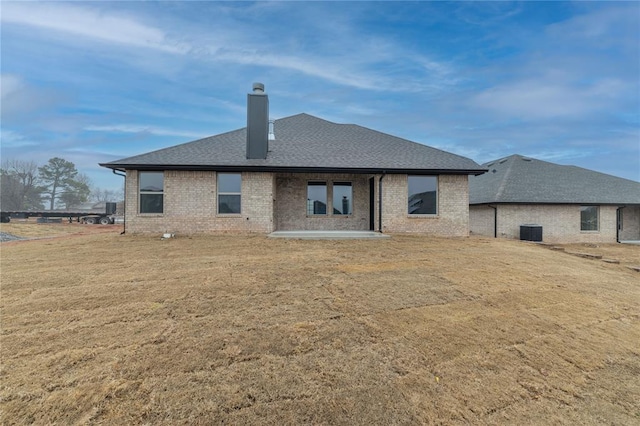 back of house featuring central AC, a patio, and a lawn