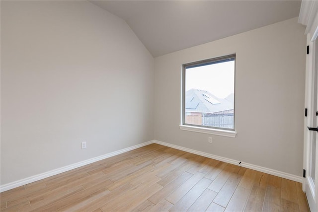 empty room featuring lofted ceiling and light hardwood / wood-style flooring