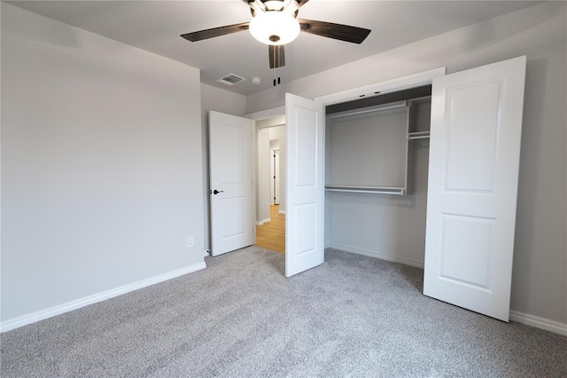 unfurnished bedroom with light colored carpet, ceiling fan, and a closet