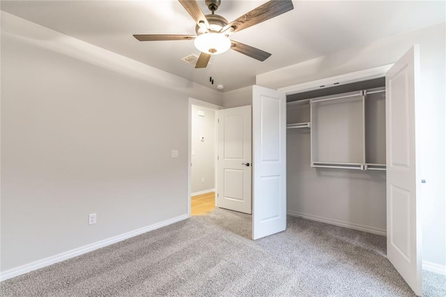 unfurnished bedroom featuring ceiling fan, light colored carpet, and a closet