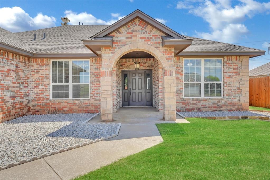 view of exterior entry with a lawn