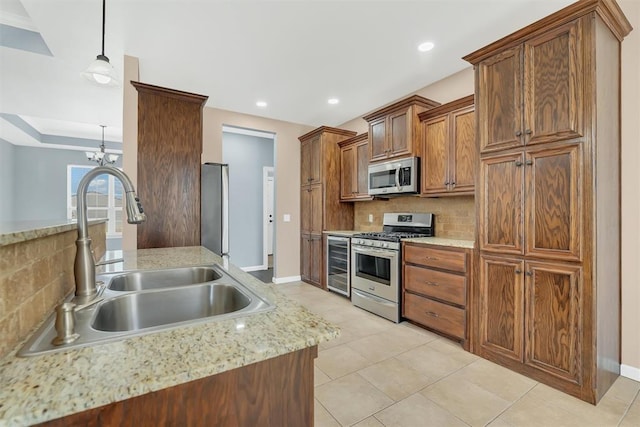 kitchen with sink, stainless steel appliances, an inviting chandelier, backsplash, and decorative light fixtures