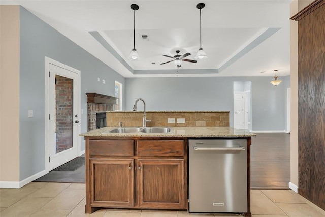 kitchen featuring dishwasher, light tile patterned flooring, a raised ceiling, and sink