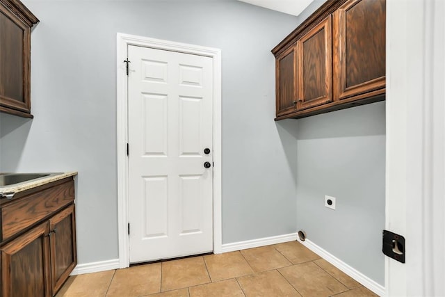 washroom with cabinets, sink, electric dryer hookup, and light tile patterned flooring