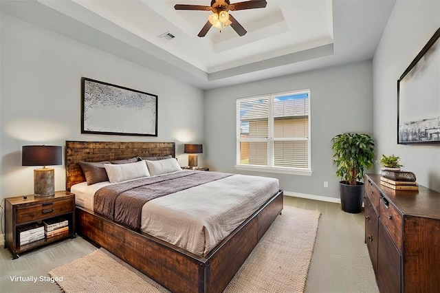 bedroom with a tray ceiling and ceiling fan