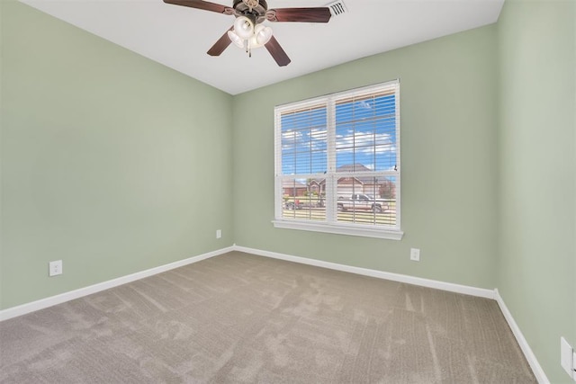 spare room with ceiling fan and light colored carpet