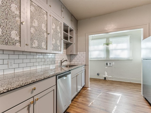 kitchen featuring white cabinetry, light stone countertops, sink, tasteful backsplash, and appliances with stainless steel finishes