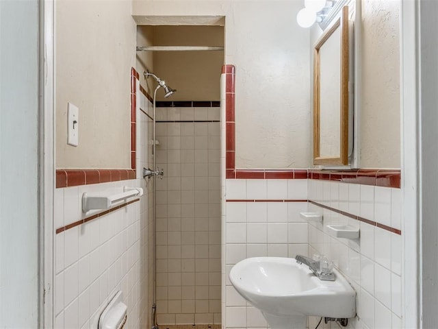 bathroom featuring a tile shower, radiator, sink, and tile walls