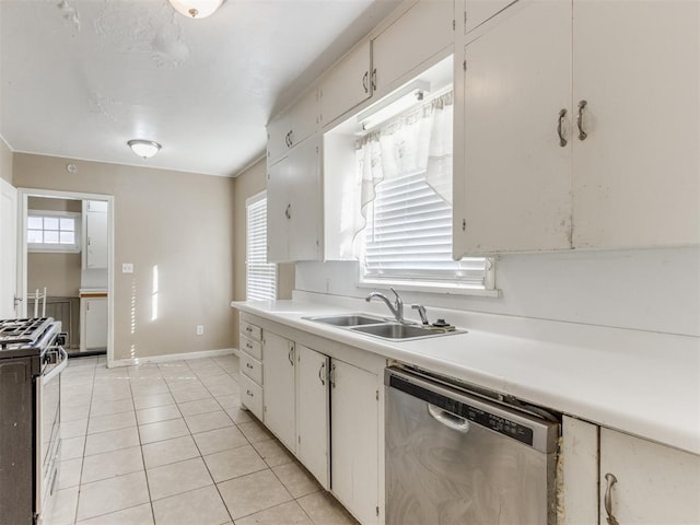 kitchen featuring white cabinetry, sink, light tile patterned floors, and appliances with stainless steel finishes