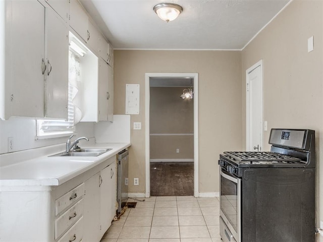 kitchen with appliances with stainless steel finishes, light tile patterned floors, white cabinetry, and sink