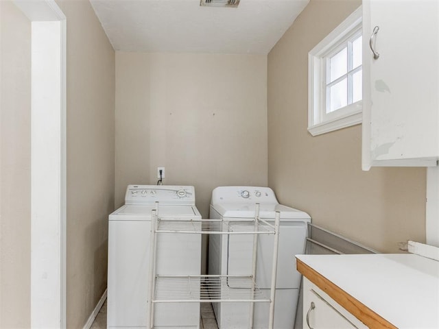 washroom with washer and dryer and cabinets