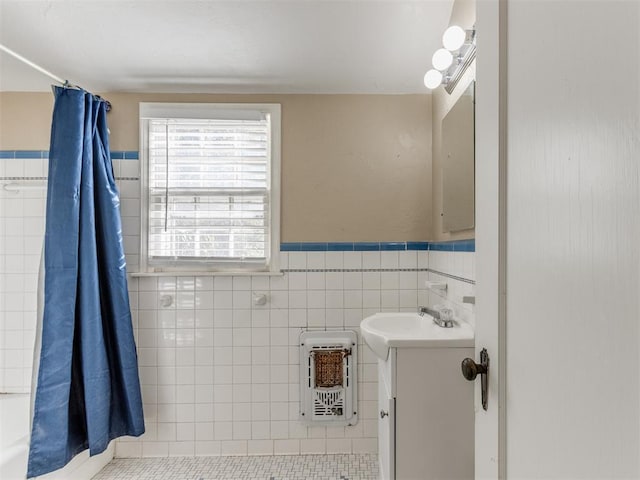 bathroom featuring tile patterned flooring, vanity, tile walls, and heating unit