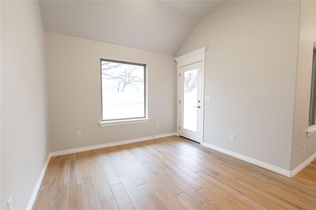 empty room with lofted ceiling and light hardwood / wood-style floors