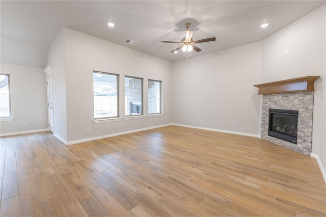 unfurnished living room with a fireplace, ceiling fan, and light wood-type flooring