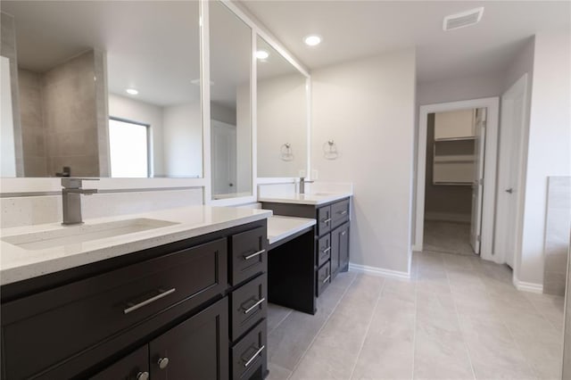 bathroom featuring vanity, tile patterned flooring, and walk in shower