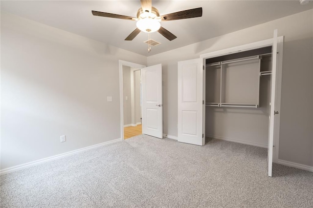 unfurnished bedroom with light colored carpet, a closet, and ceiling fan