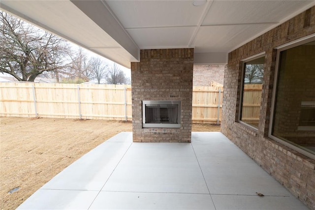 view of patio featuring an outdoor brick fireplace