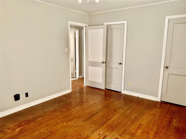 unfurnished bedroom featuring dark hardwood / wood-style floors and ornamental molding