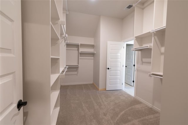 walk in closet featuring light carpet