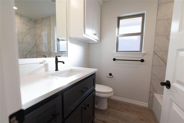 full bathroom with toilet, vanity, tiled shower / bath combo, and a wealth of natural light